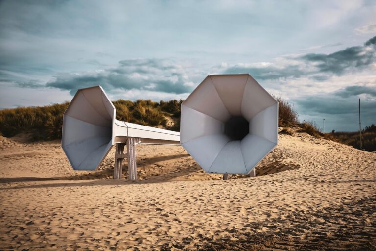 Spiaggia con sabbia che produce suoni melodici quando calpestata, circondata da cartelli di protezione.