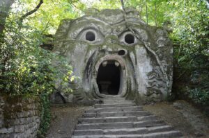 Sculture giganti e misteriose nel Parco dei Mostri di Bomarzo, circondate da alberi e natura.