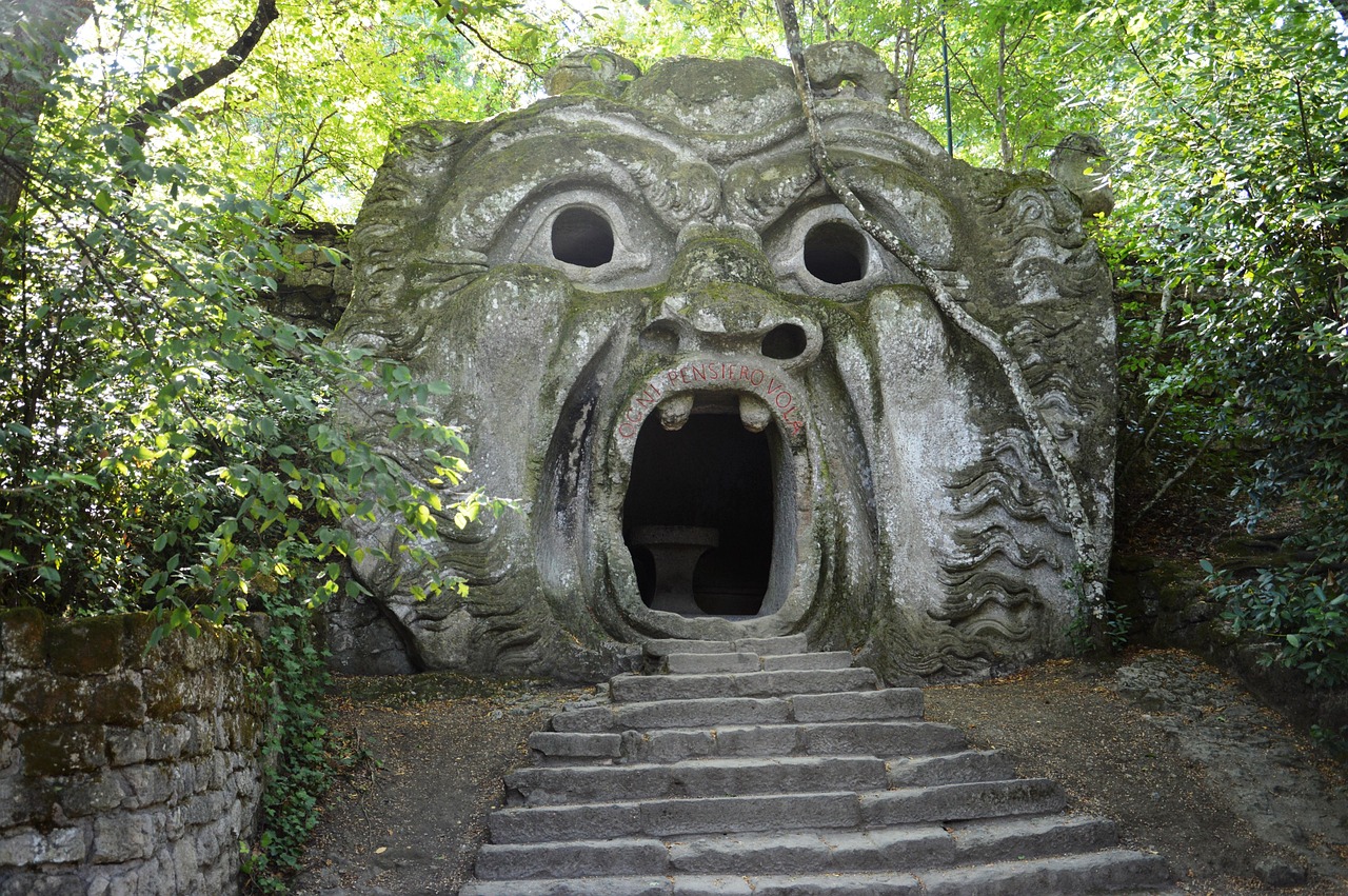Sculture giganti e misteriose nel Parco dei Mostri di Bomarzo, circondate da alberi e natura.
